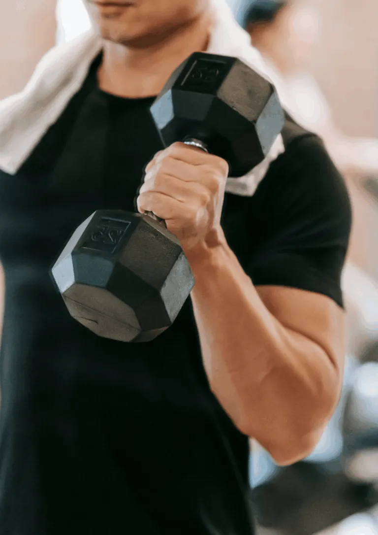 Sportists veic spēka treniņu ar hantelēm