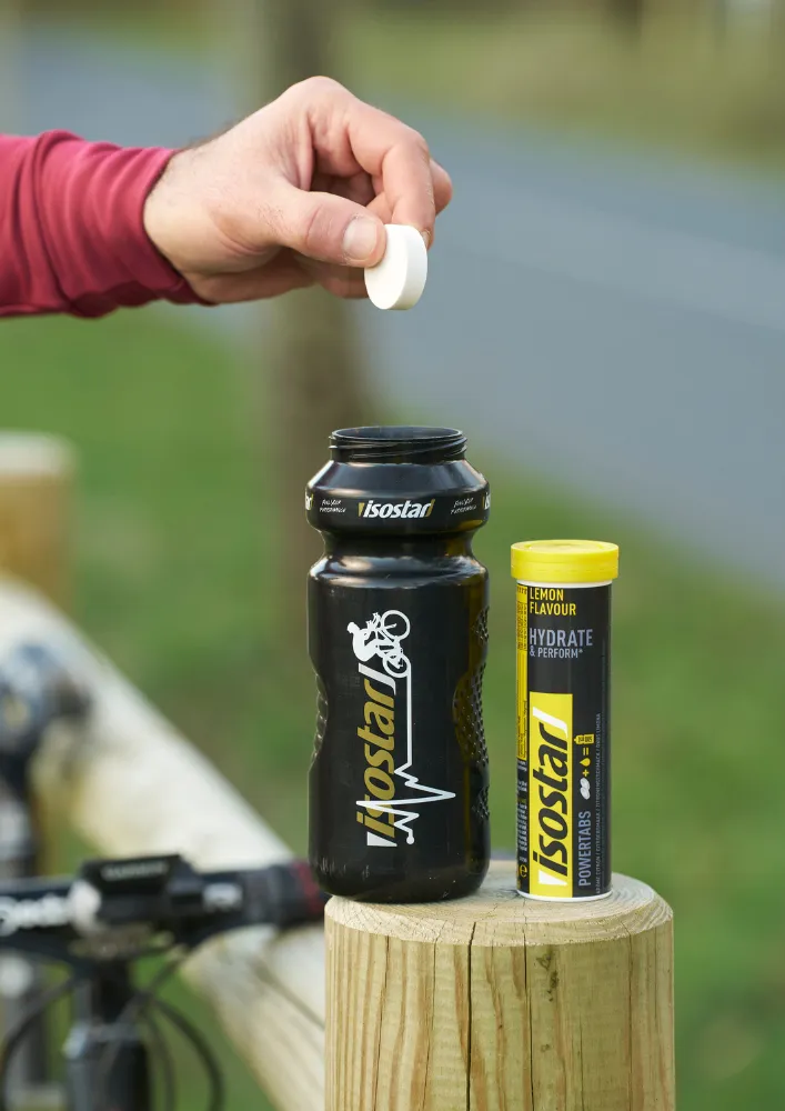 Isostar elektrolītu tablete tiek pievienota sporta pudelei